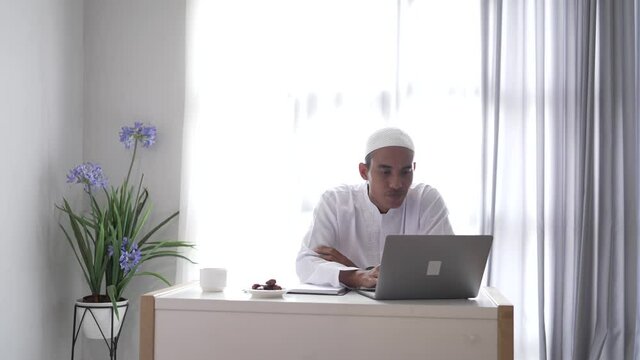 happy asian muslim man meeting using laptop for video call conference