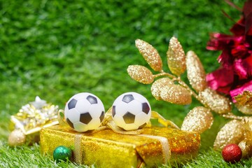 Soccer ball for Christmas Decoration are on green grass 