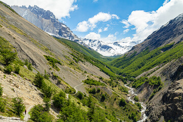 trilhas do circuito w no vale da Ascensão, com rio ao fundo montanhas com florestas verdes e ao fundo montanhas com neve em um lindo dia de sol e azul 