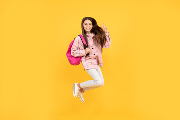 Fototapeta na wymiar teen girl jump in checkered shirt. happy kid run with backpack. tween child carry school bag.