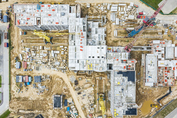 new building under construction with working cranes. aerial drone top down view.