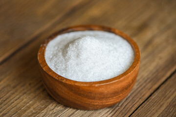 Monosodium glutamate on wooden bowl on the table background, MSG for food seasoning