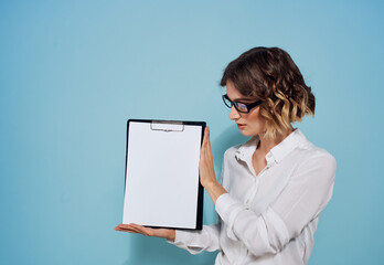 Business woman with a folder and a white sheet of paper on a blue background glasses on her face