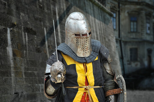 Medieval knight in armor with sword and shield against the background of the castle