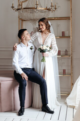 Portrait of the bride and groom in a lace dress in boho style with a bouquet.