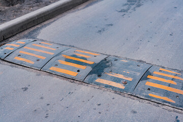 Bolted down speed bump line made of rubber on asphalt road. Sleeping policemen. Street. Low speed....