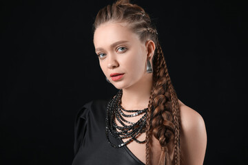Fototapeta premium Beautiful young woman with braided hair on dark background