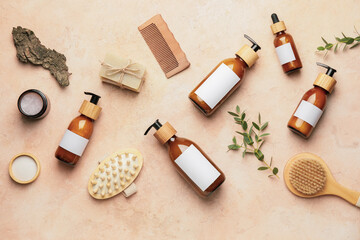 Bottles with natural shampoo, brushes and soap on color background