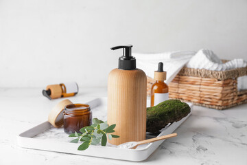 Fototapeta na wymiar Bottle with natural shampoo on light background