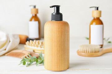 Bottle with natural shampoo on light wooden background