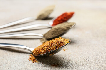 Spoons with different spices on light background, closeup