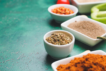 Bowls with different spices on color background, closeup