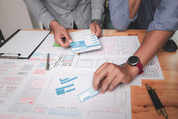 UX or UI designers designing on their smartphone application layout prototype project.