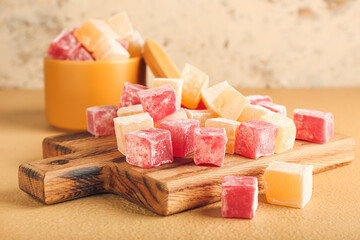 Board with Turkish delight on color background