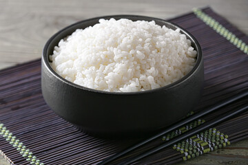 Bowl with tasty rice on dark background