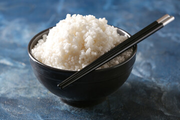 Bowl with tasty rice on color background