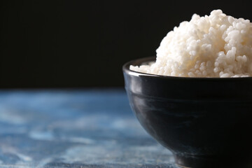 Bowl with tasty rice on color background, closeup