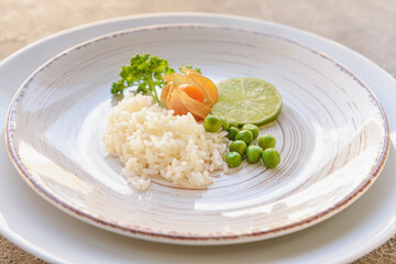 Plate with tasty rice, green peas and physalis, closeup