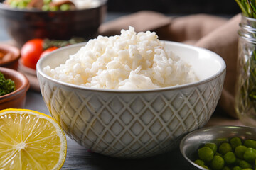Bowl with tasty rice on dark background, closeup