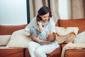 Young woman with child playing on couch