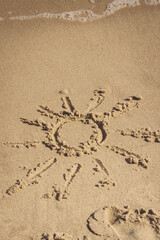 Shape of sun on sand at beach and incoming sea wave. Summer, vacation time and tourism