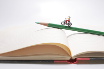 A Girl rides on a motorcycle over open diary book. Travel concept