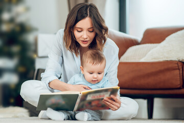 Focused mom reading book to small child