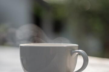 White coffee cup on natural blur background.