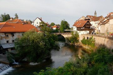 Fototapeta na wymiar river run across the city of Skofja-Loka, Slovenia. Old walled city