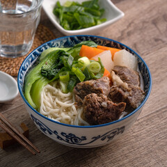 Beef noodle soup. Close up of Taiwanese famous food in a bowl on wooden table.