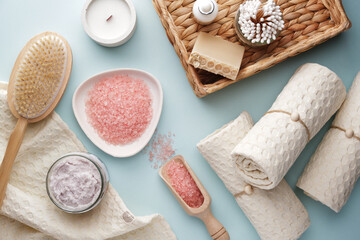 Pink bath salt, scrub, handmade soap, bamboo cotton swabs, muslin towels and other body care supplies. View from above.