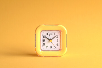 Yellow clock on yellow background.
