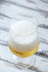 Glass of beer on bright wooden background. Close up.