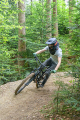 Mountainbiker bef&auml;hrt einen Waldtrail in einem Bikepark