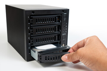 Fototapeta premium Hand installs enclosur with personal rack hard drive, rack home use or pesonal portable hard drive rack for personal cloud at home isolated on white background. Personal or private rack hard disk.