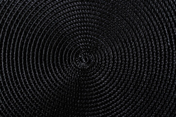 Closeup of a black mat, spiral texture, contrast, abstract background
