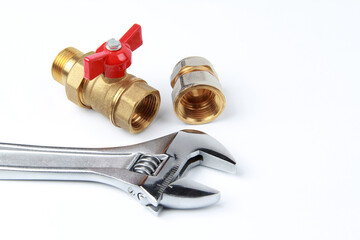 New metal adjustable adjustable steel key and brass water tap with adapter on white background. The concept of repair and connection of plumbing or gas installations. Copyspace.