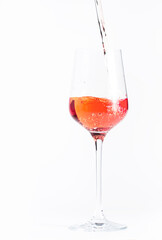 Rose wine pouring out of the bottle, white bakcground. Rosado, rosato or blush wine tasting in wineshop, bar concept. Copy Space