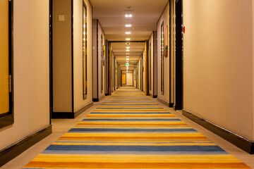 interior of the hotel is a long corridor with a striped walkway.