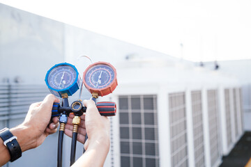 Technician is checking air conditioner ,measuring equipment for filling air conditioners.Cooling system