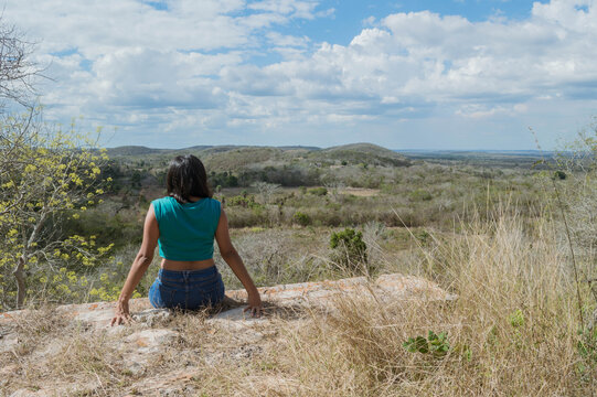 Mujer de espaldas observando el horizonte desde un acantilado. Tekax, Yucatán