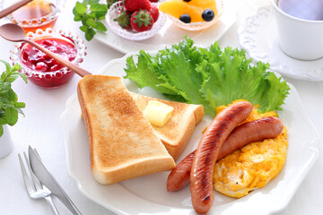 Breakfast plate with buttered toast, scrambled egg and sausage....