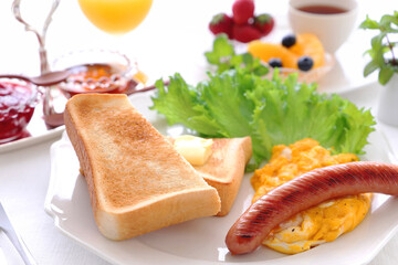 Breakfast plate with buttered toast, scrambled egg and sausage. トースト　たまご　ソーセージ　朝食
