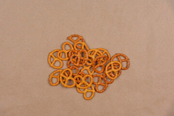 Several salted pretzels lie on craft paper.