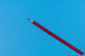 One red pencil on a blue background