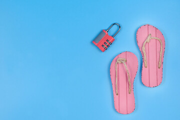 Slippers and combination lock on a blue background.