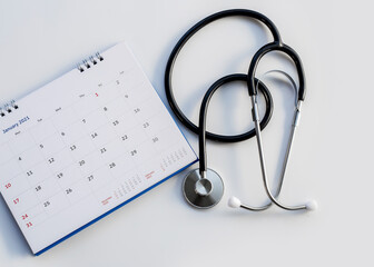 Headphones with date on the calendar page on a gray background Health care concept.	