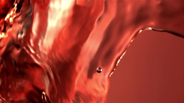 Super slow motion of the rocket of pomegranate juice pours. Macro background. Filmed on a high-speed camera at 1000 fps. High quality FullHD footage