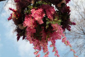 Artificial flowers are hung in the city garden.