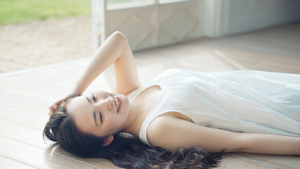 Obraz premium 床に寝そべる女性 美容 ヘアケア